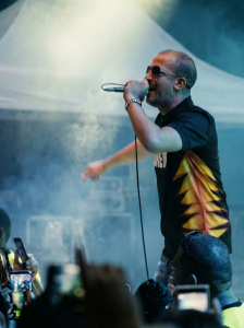 l'Artiste Rim'K du 113 sur scène en plein concert, photographié depuis le public avec des spectateurs filmant via leurs smartphones. Exemple de l'ambiance capturée lors d'une prestation de film événementiel par Noswil production.